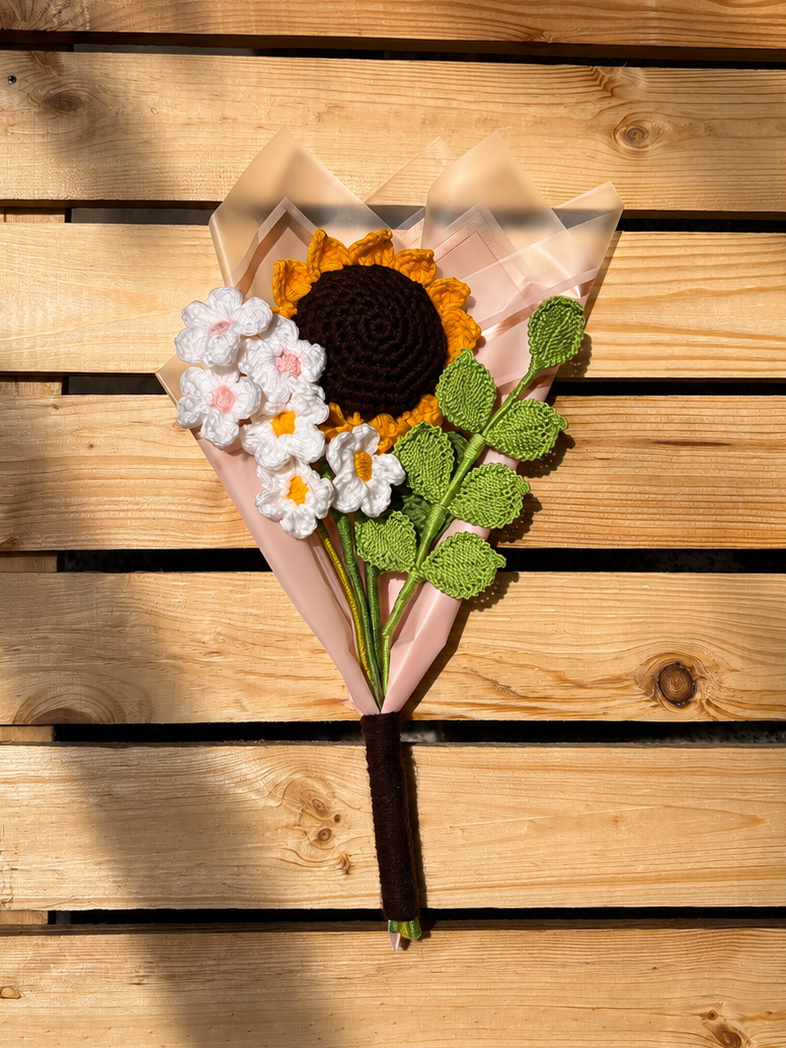 Bouquet of sunflowers and white flowers in clear plastic on a wooden surface